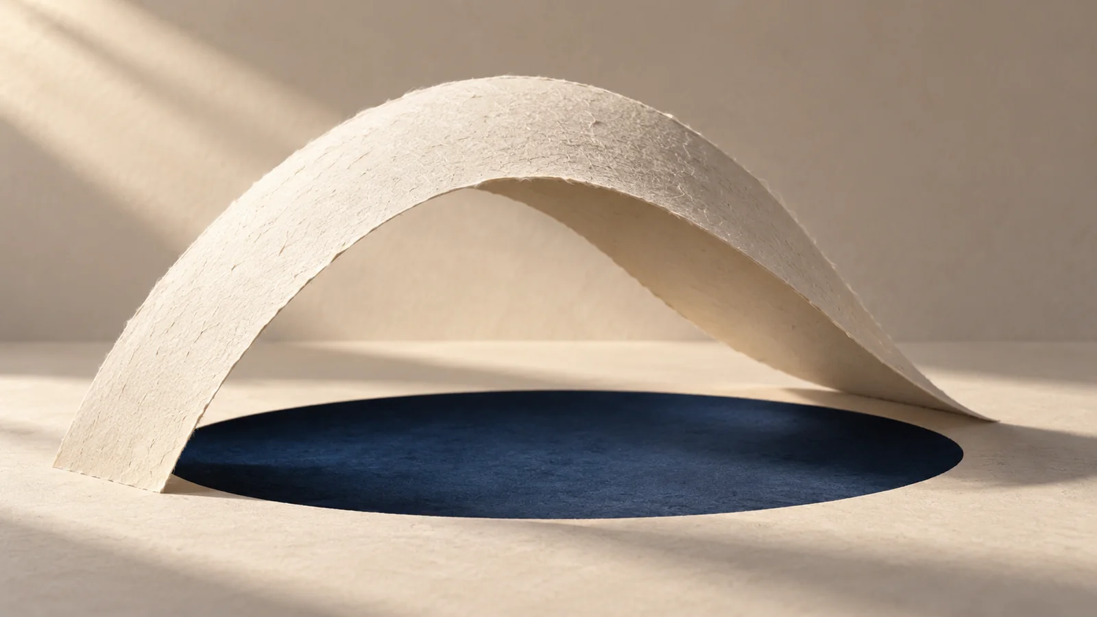 Ivory paper arch casting a curved shadow over an indigo oval