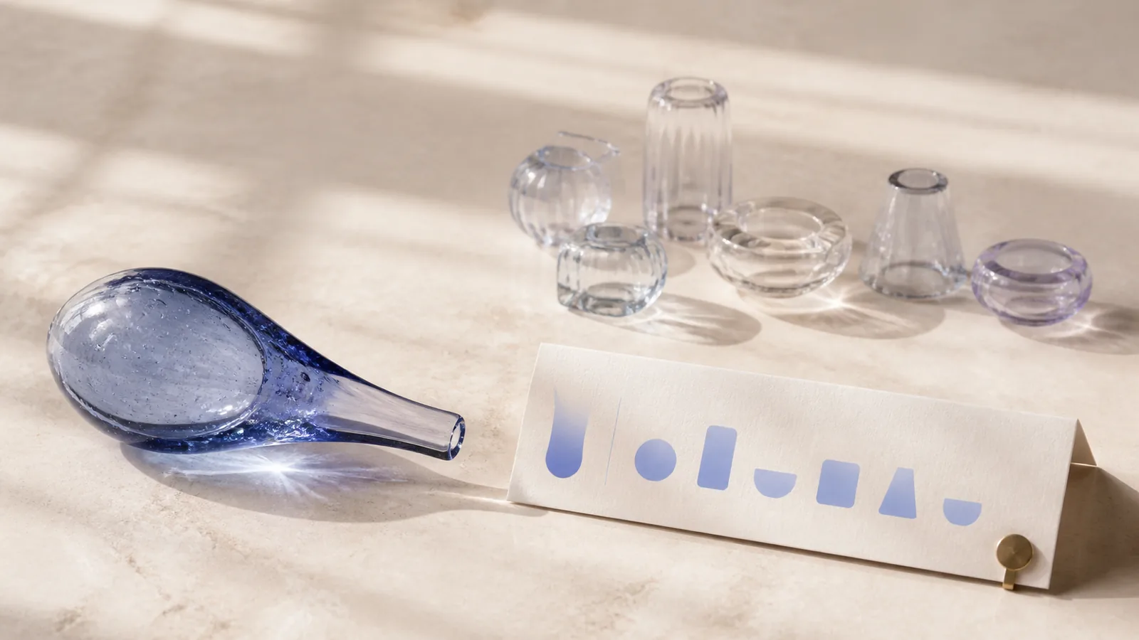 Clear measured vessels and abstract lip-shaped tiles arranged as quote components